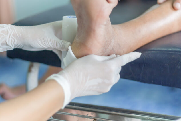 Doctor doing leg treatment for patient